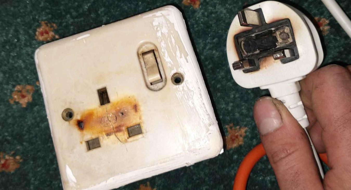 A burnt plug top and socket found in a hospitality business in Rochester, Kent