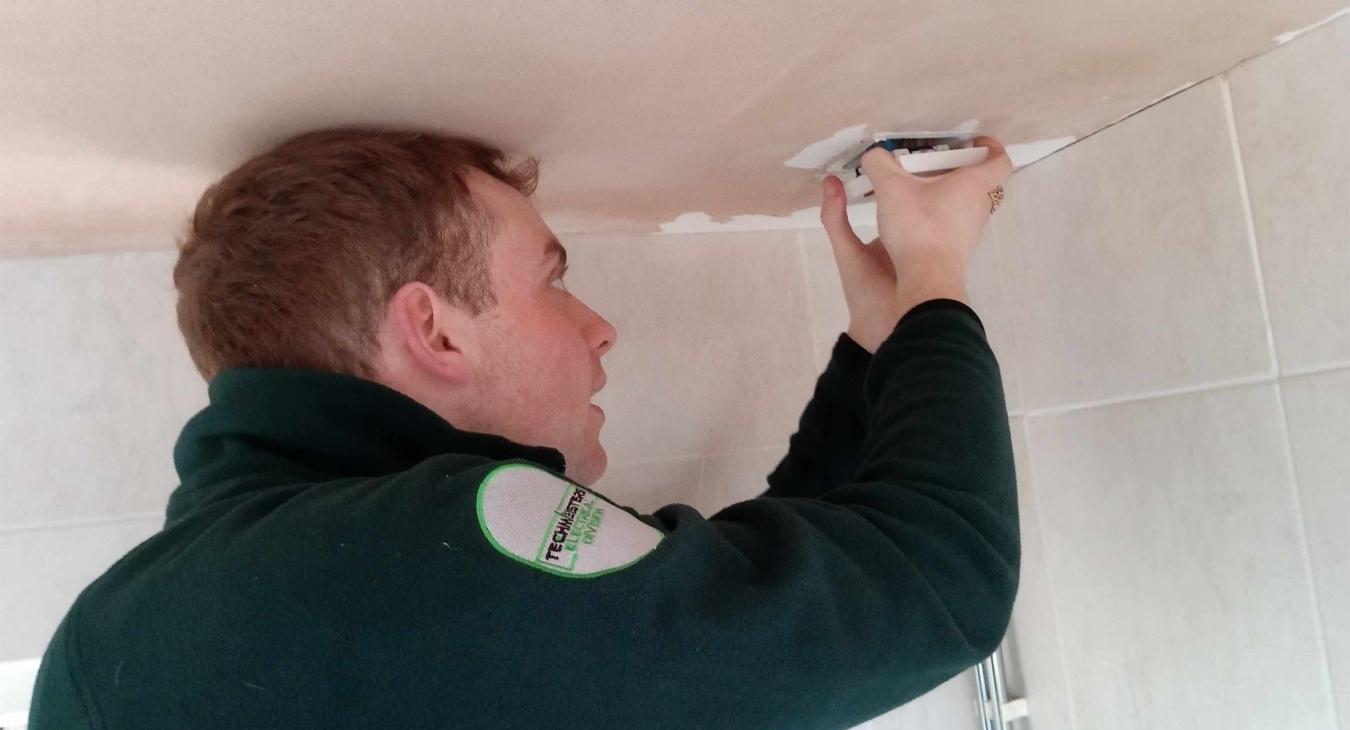 An electrician's apprentice being supervised on a small electrical job