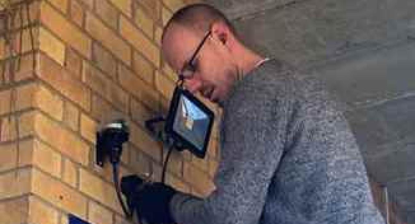 Installing a new floodlight at a high street shop