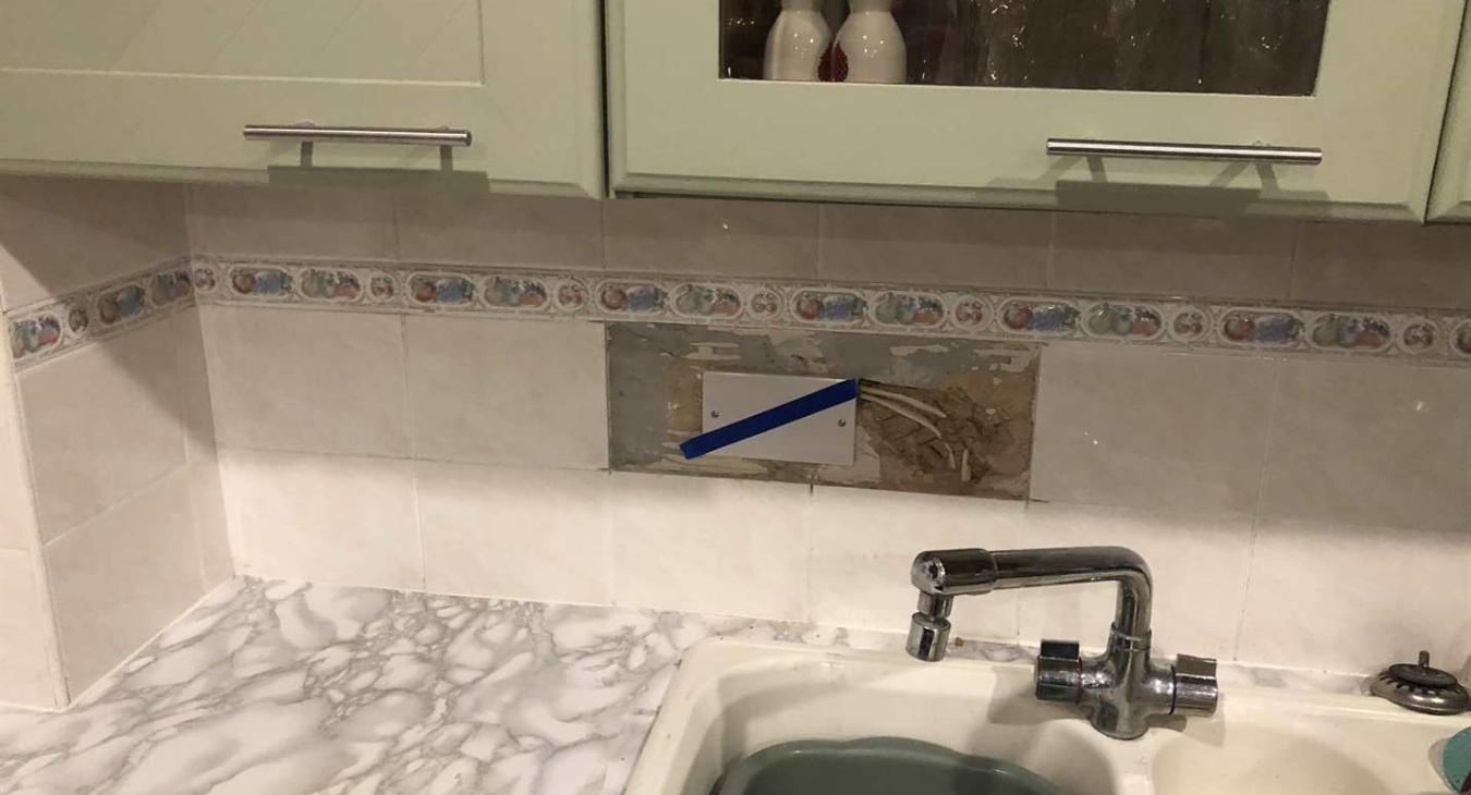 Hidden electrical junction boxes tiled into kitchen wall