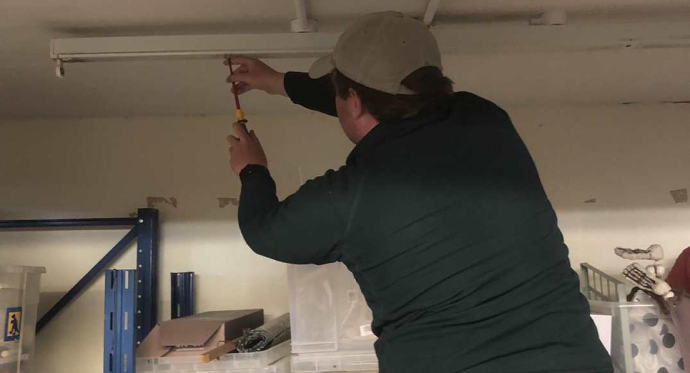 shop electrician replacing faulty light